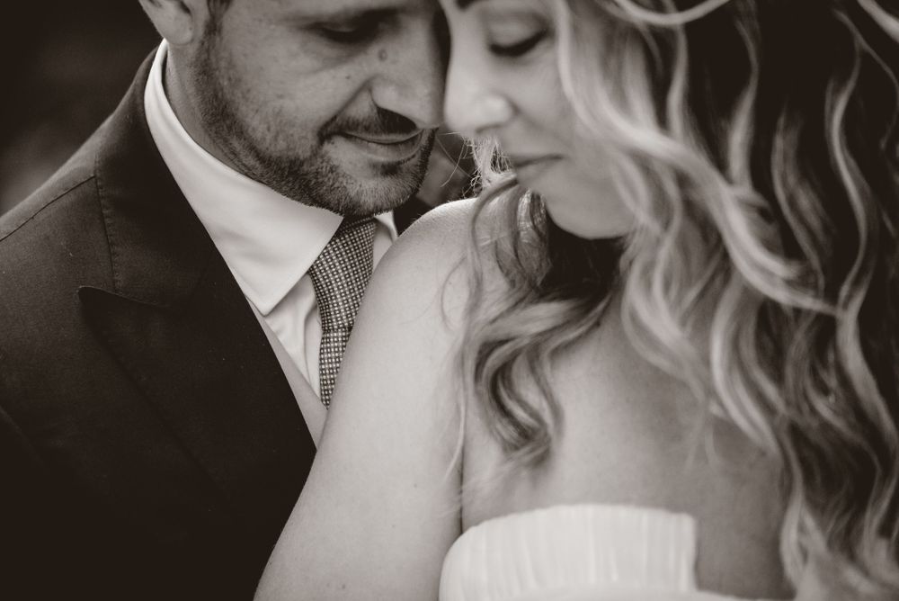 Intimate black and white close-up of wedding couple sharing tender moment.