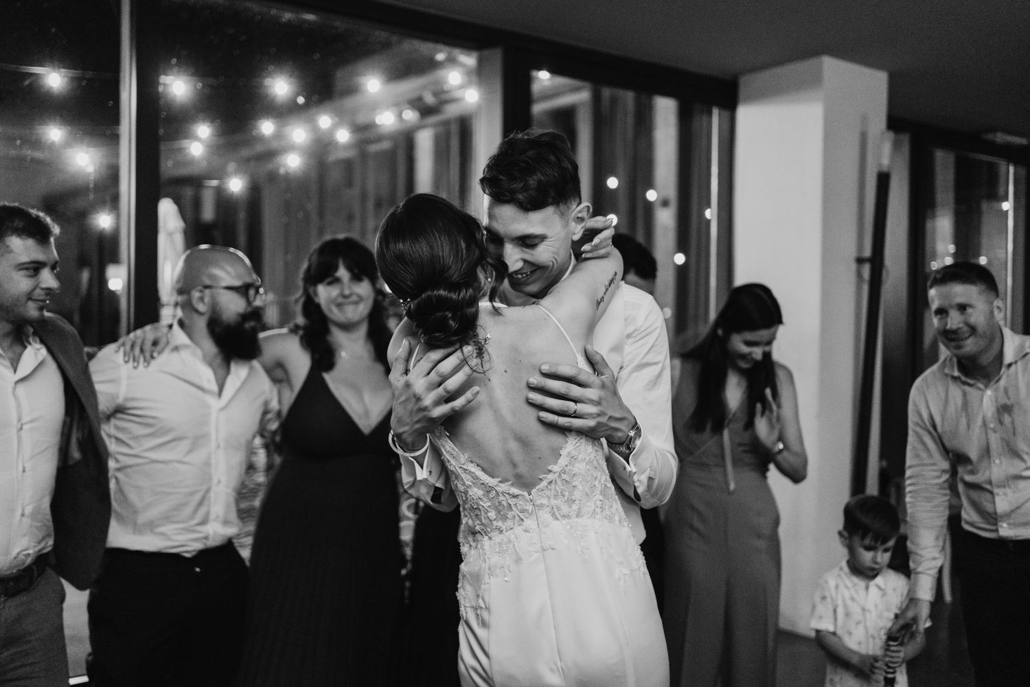 Newlyweds share an emotional first dance while guests watch and celebrate at their wedding reception.