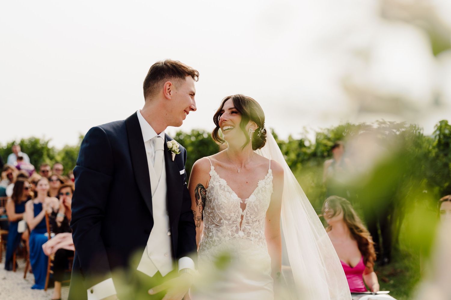 Happy bride and groom sharing a loving glance during outdoor wedding ceremony.