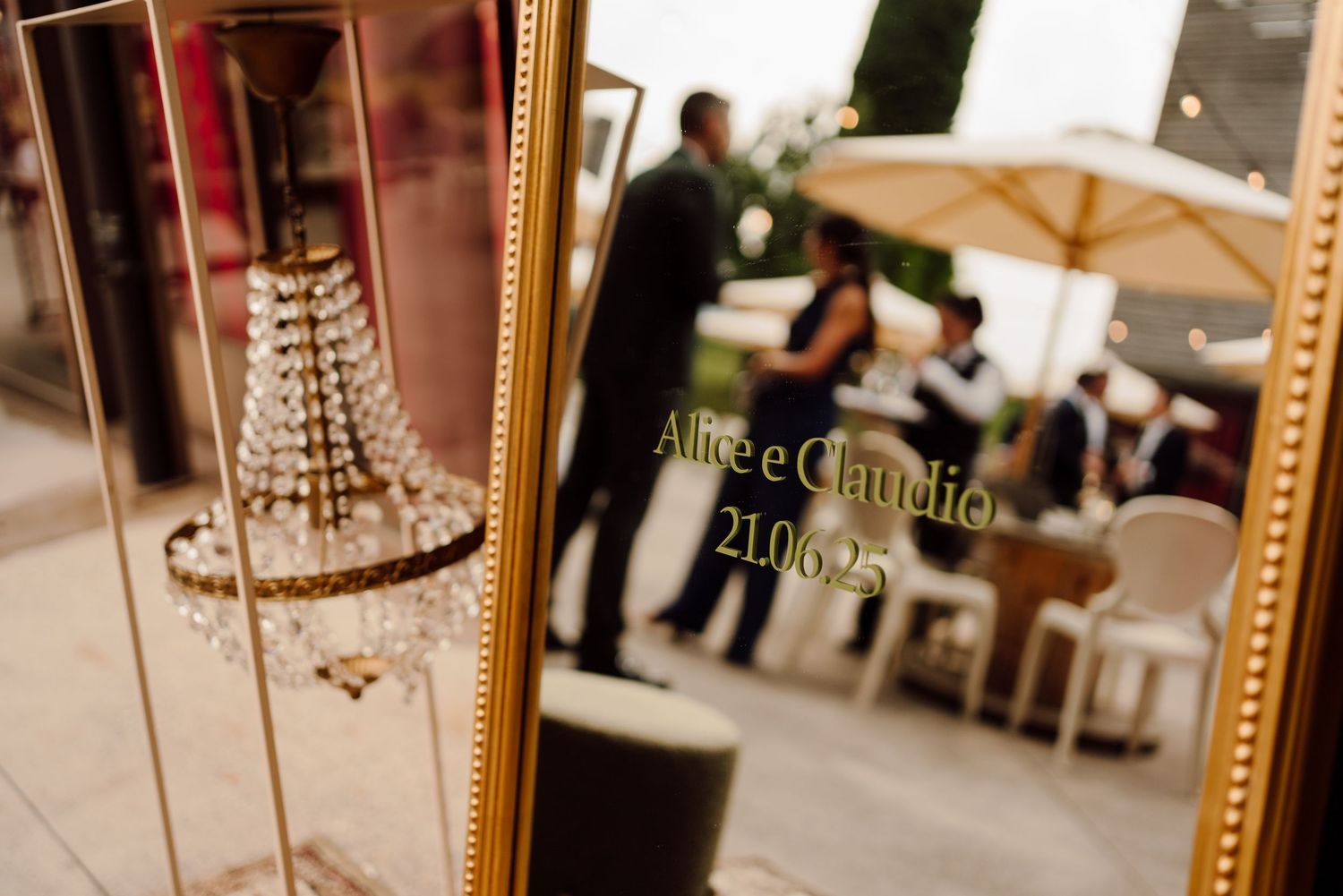 Gold-framed mirror engraved with wedding names Alice e Claudia and date 21.06.25 at a winery reception.