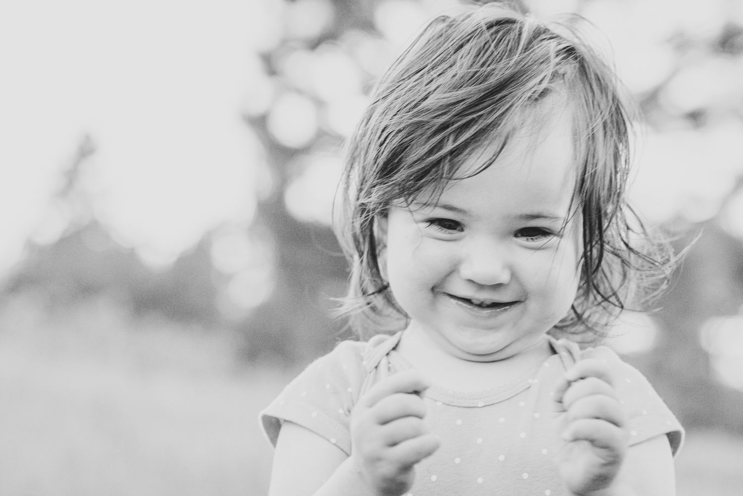 Black and white close-up portrait of a smiling child.