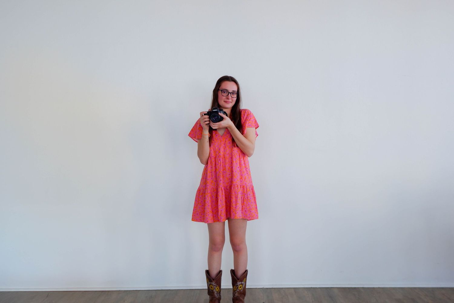 Shannon Lily Crosby Photography, a photo of Shannon holding a camera in a pink dress