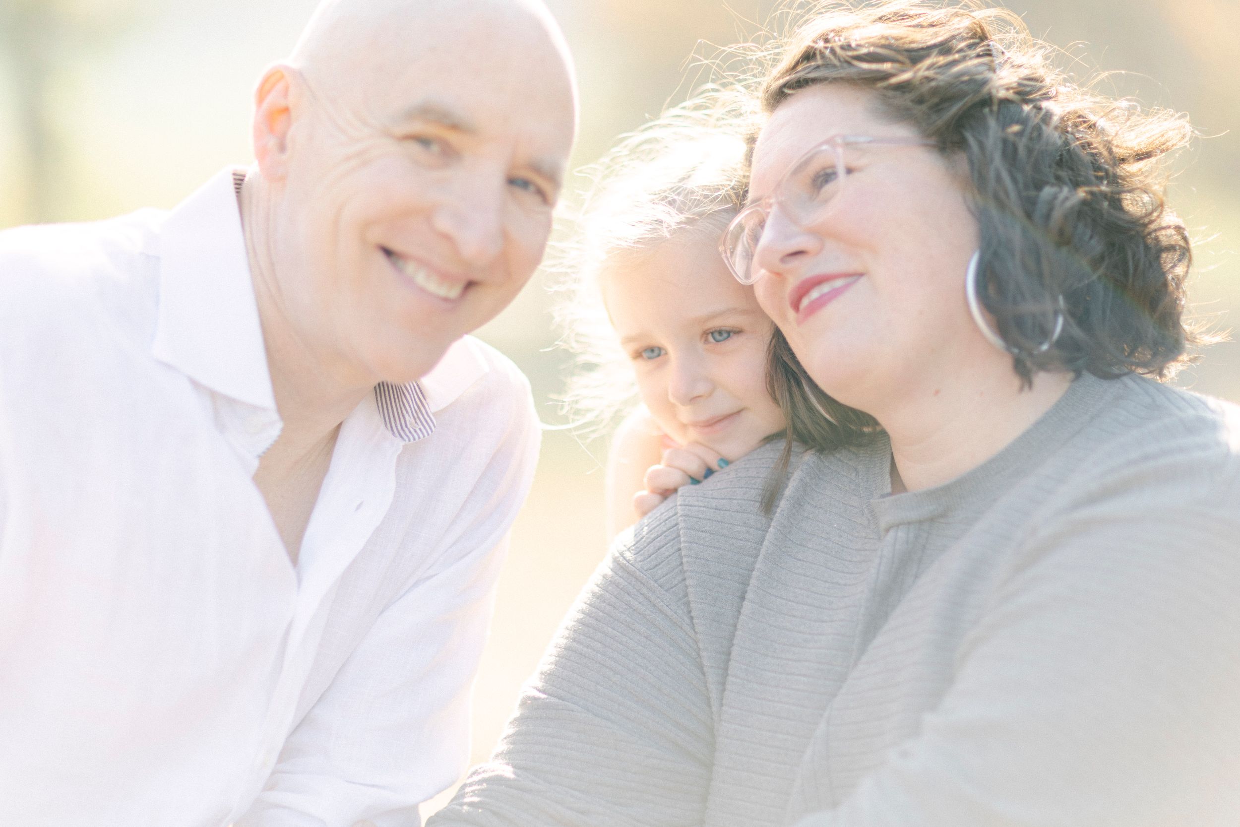 A heartwarming family portrait with soft backlighting creating a dreamy atmosphere.
