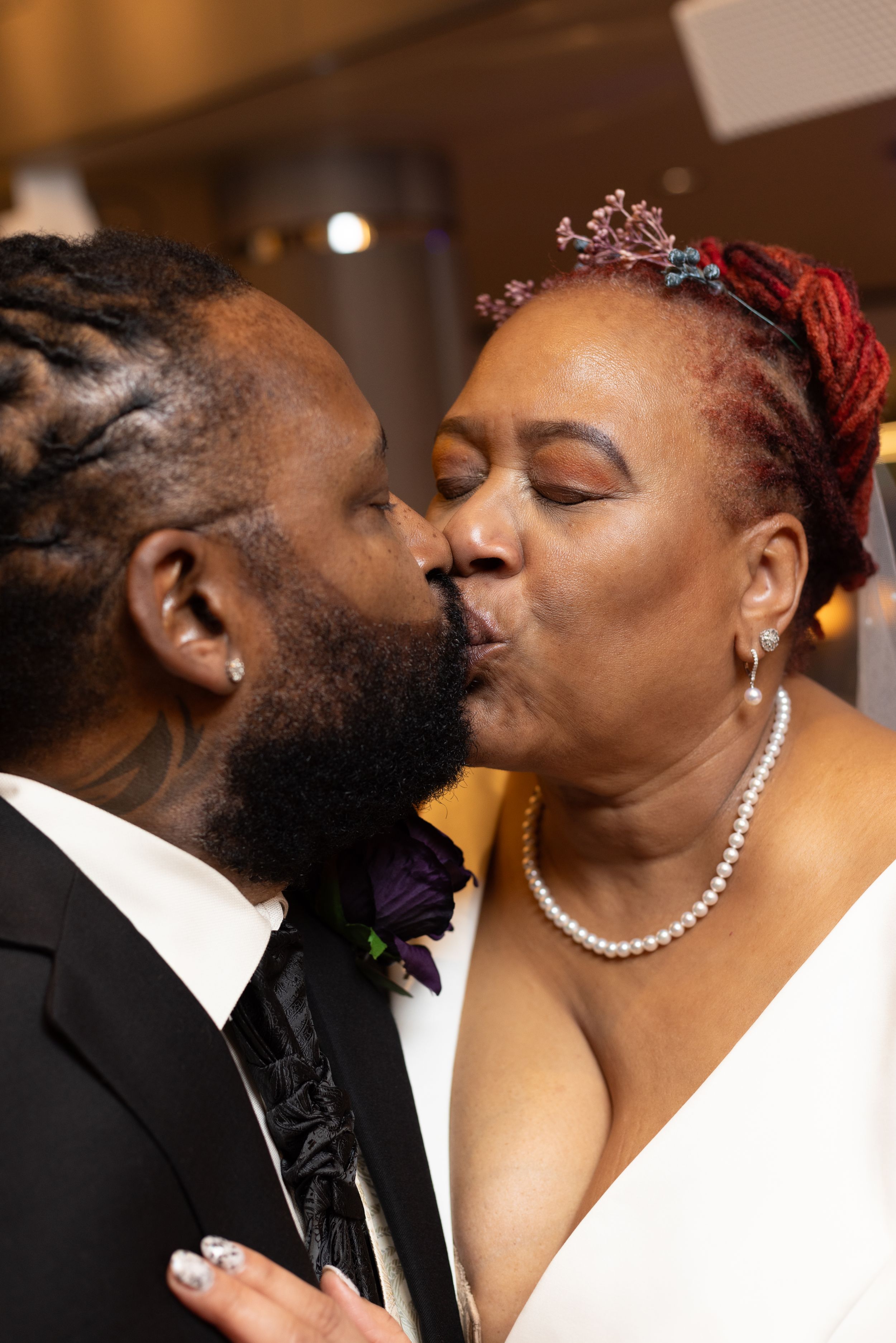 Intimate moment between newlyweds sharing a kiss during their wedding celebration.