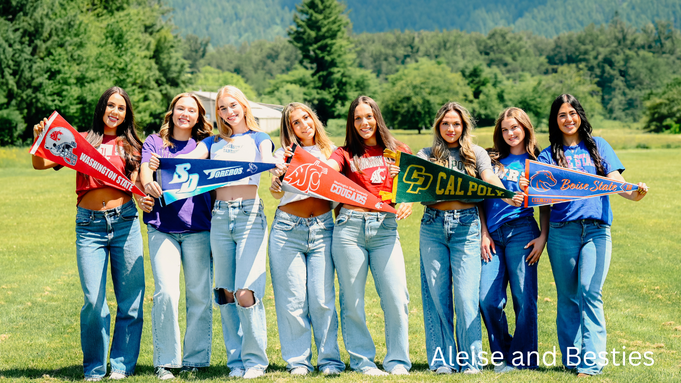 Group photo of people in matching denim jeans standing in a line against mountain scenery.