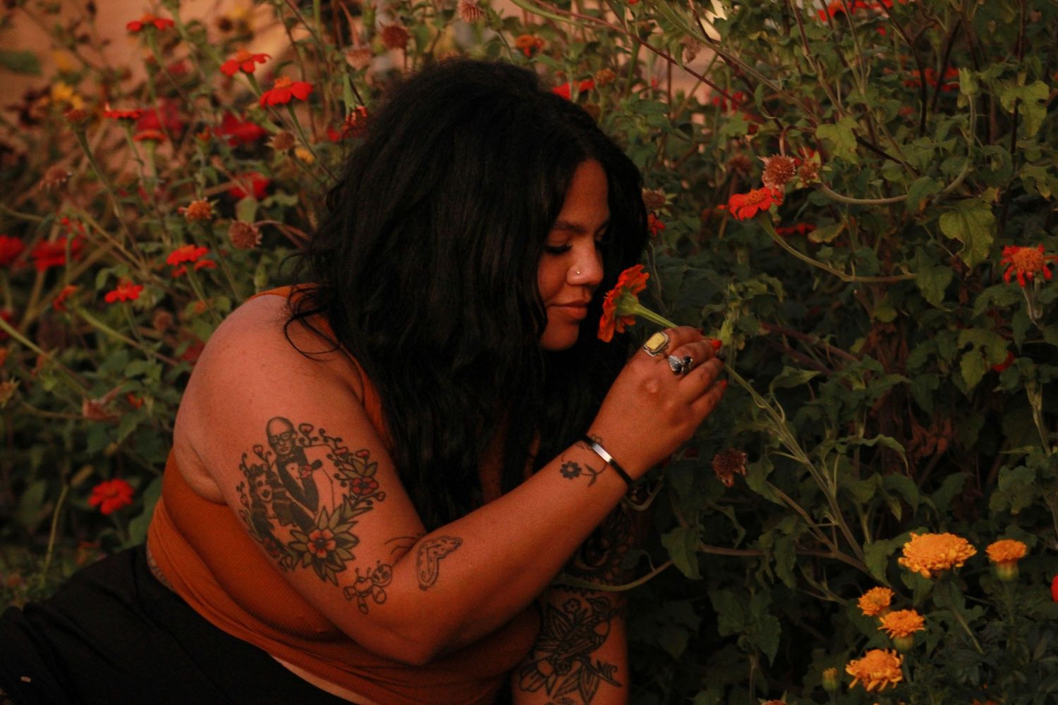 An artistic portrait among colorful garden flowers at dusk.