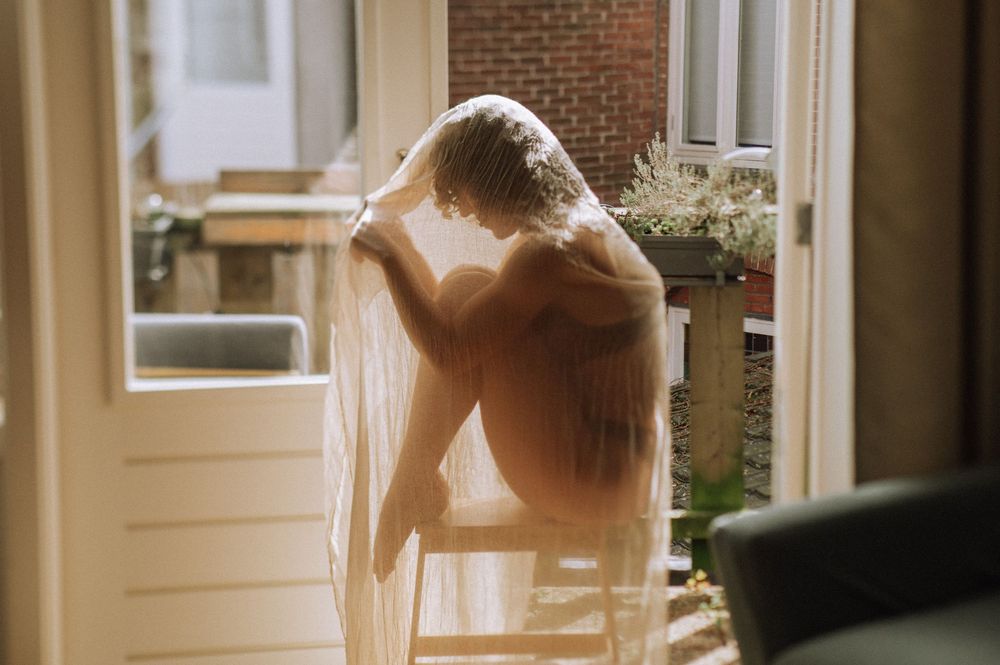 Sunlit interior scene through sheer curtains creating a dreamy atmospheric effect.