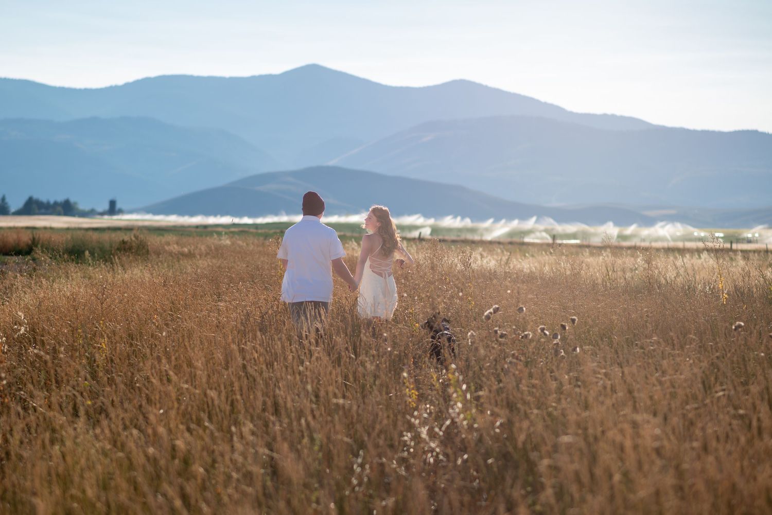 Romantic engagement session with couple running through an open field.