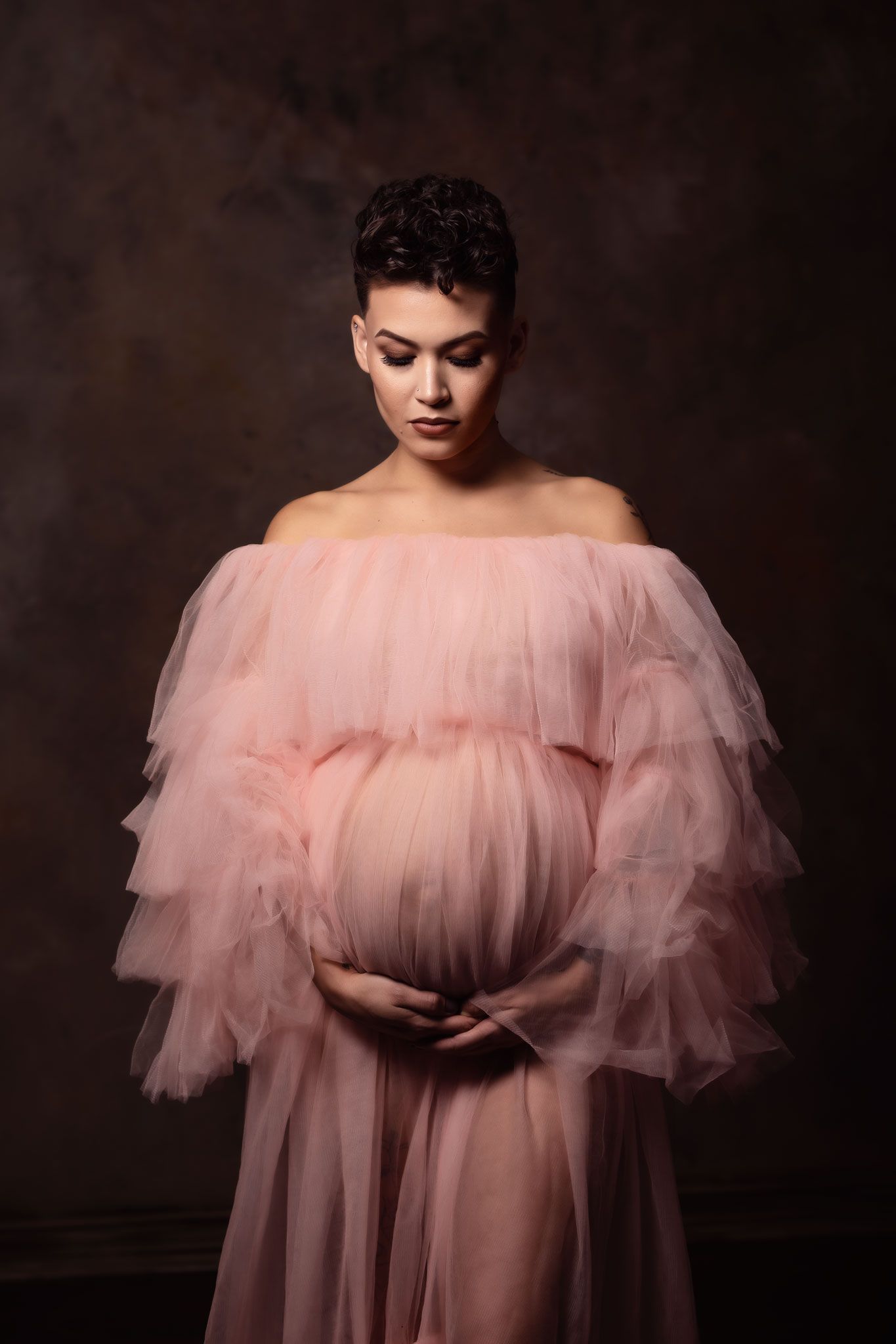 A figure in a romantic pink tulle dress poses against a dark background in a series of artistic portraits.