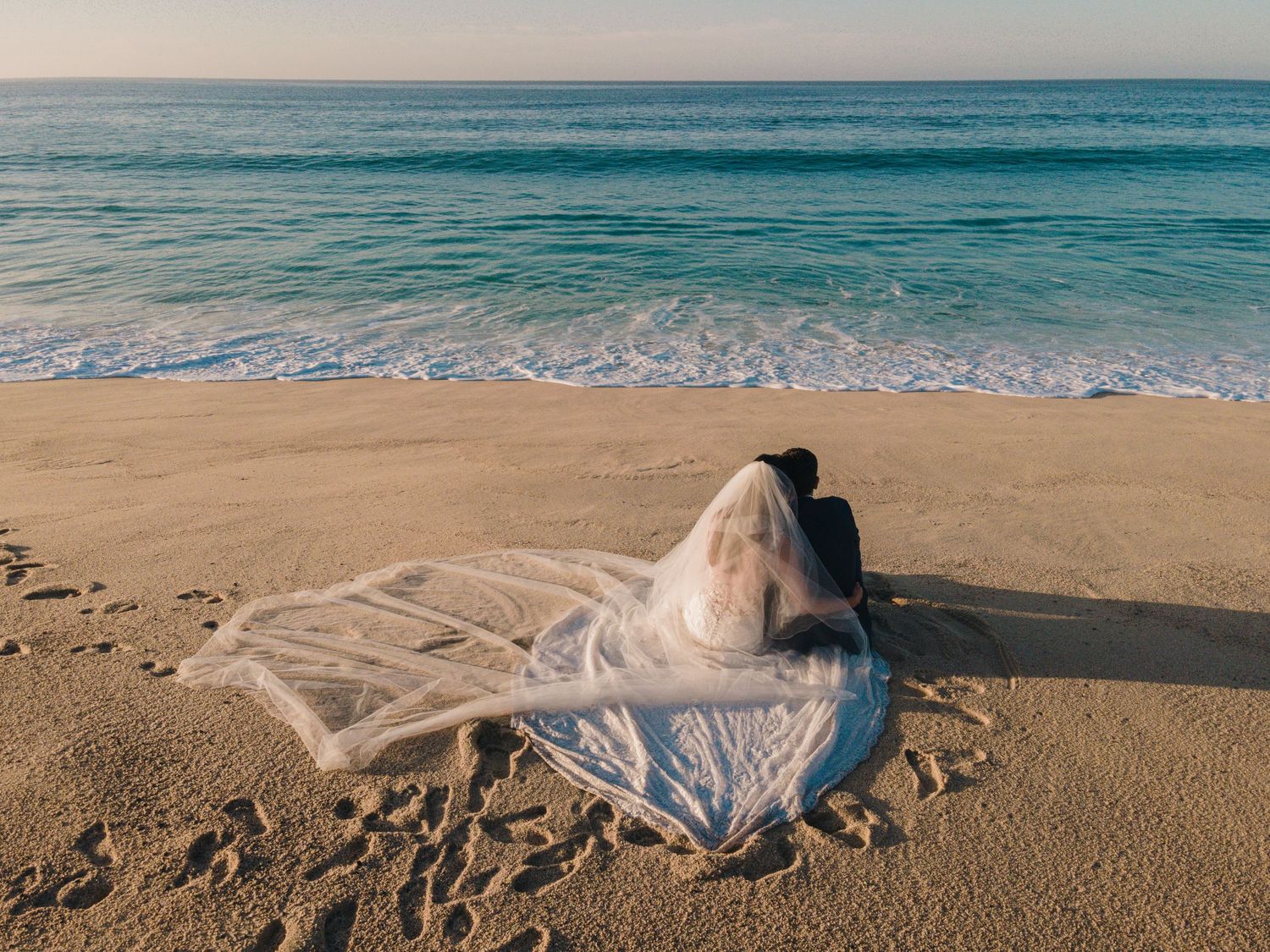 Wedding couple walking on the beach in Los Cabos at sunset