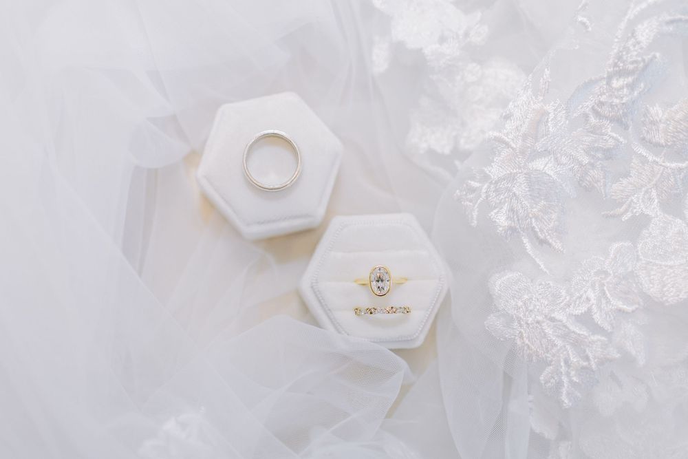 White hexagonal ceramic ring dishes with delicate gold trim arranged on a light marble surface with scattered crystals.