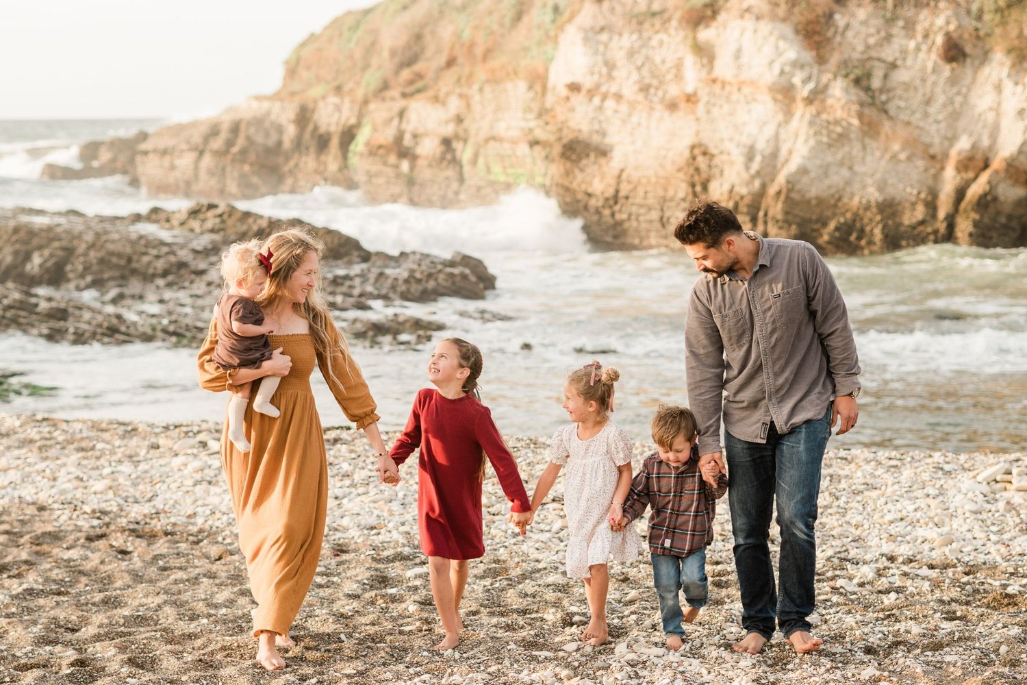 family holding hands and walking during fall family session at Montana de Oro State Par in San Luis Obispo County