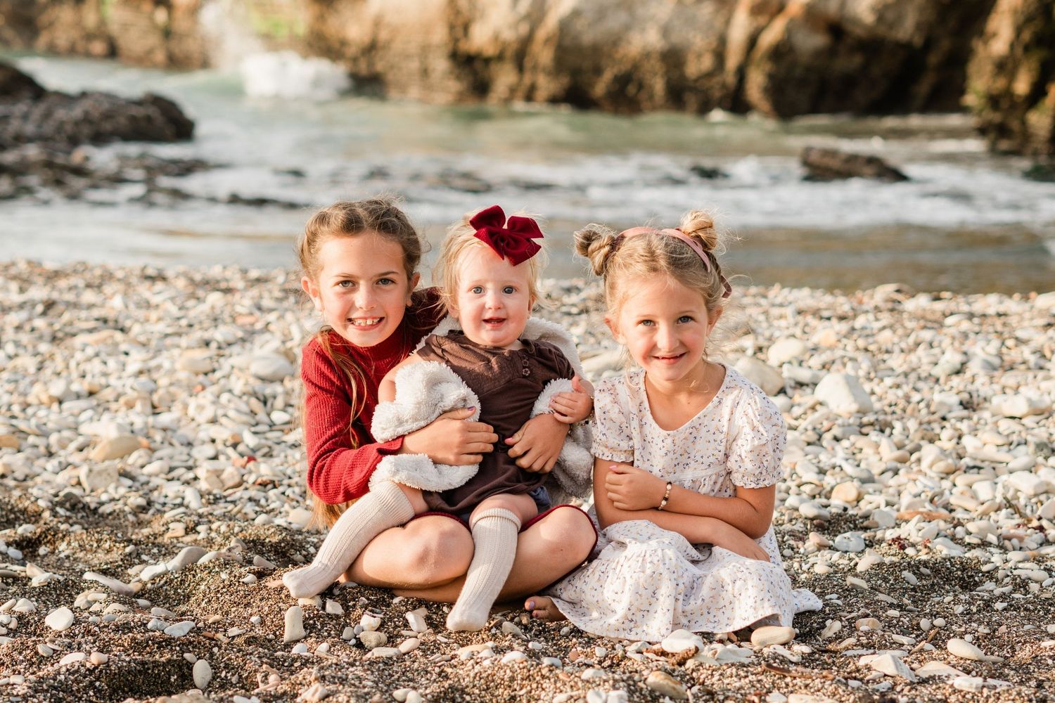 siblings sitting on beach smiling at the camera during fall family photo session at Montana de Oro in San Luis Obispo county