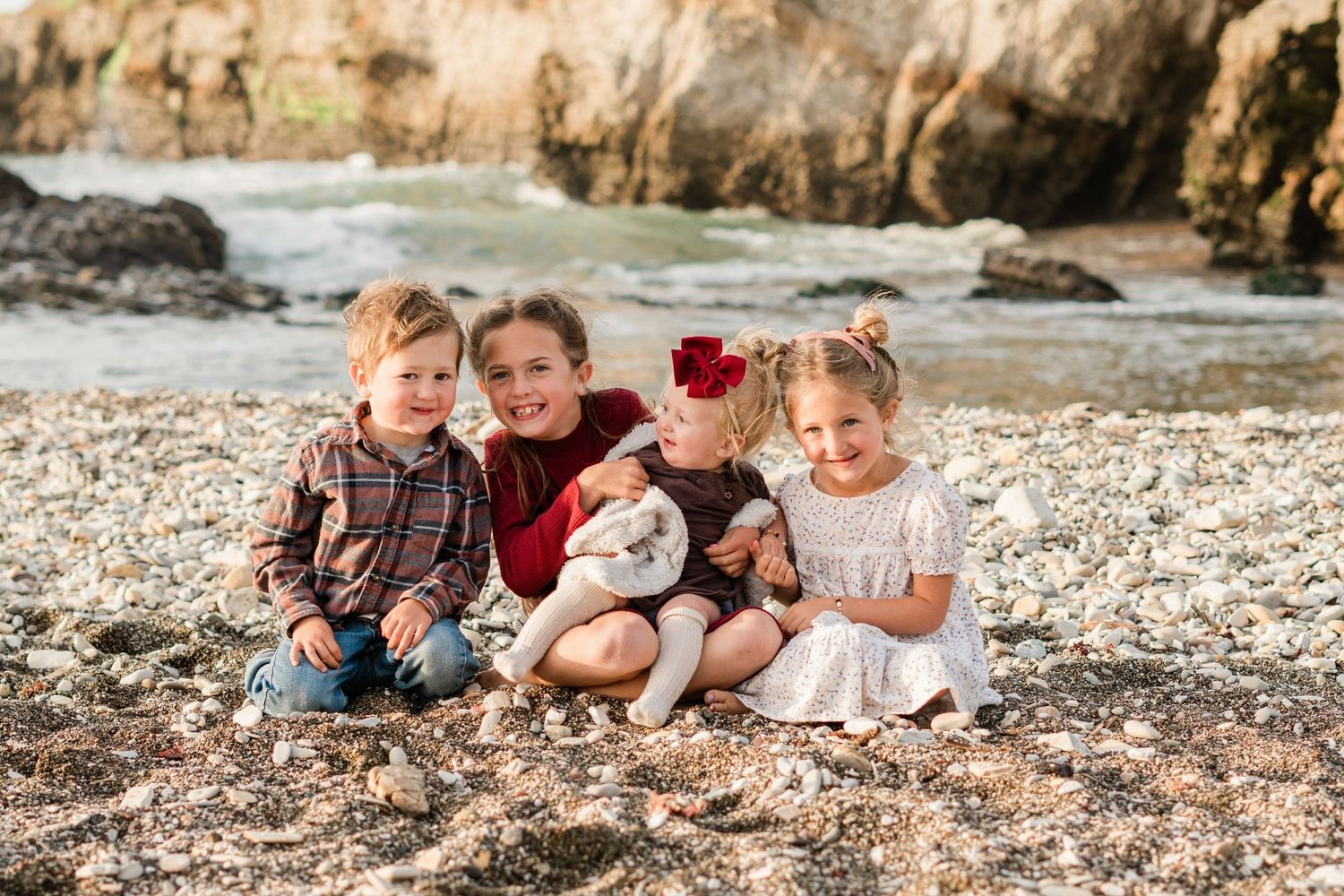 fall family photos at Montana de Oro on the central coast. kids sitting together on the beach