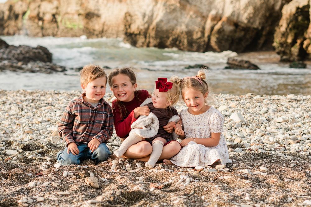 fall family photos at Montana de Oro on the central coast. kids sitting together on the beach