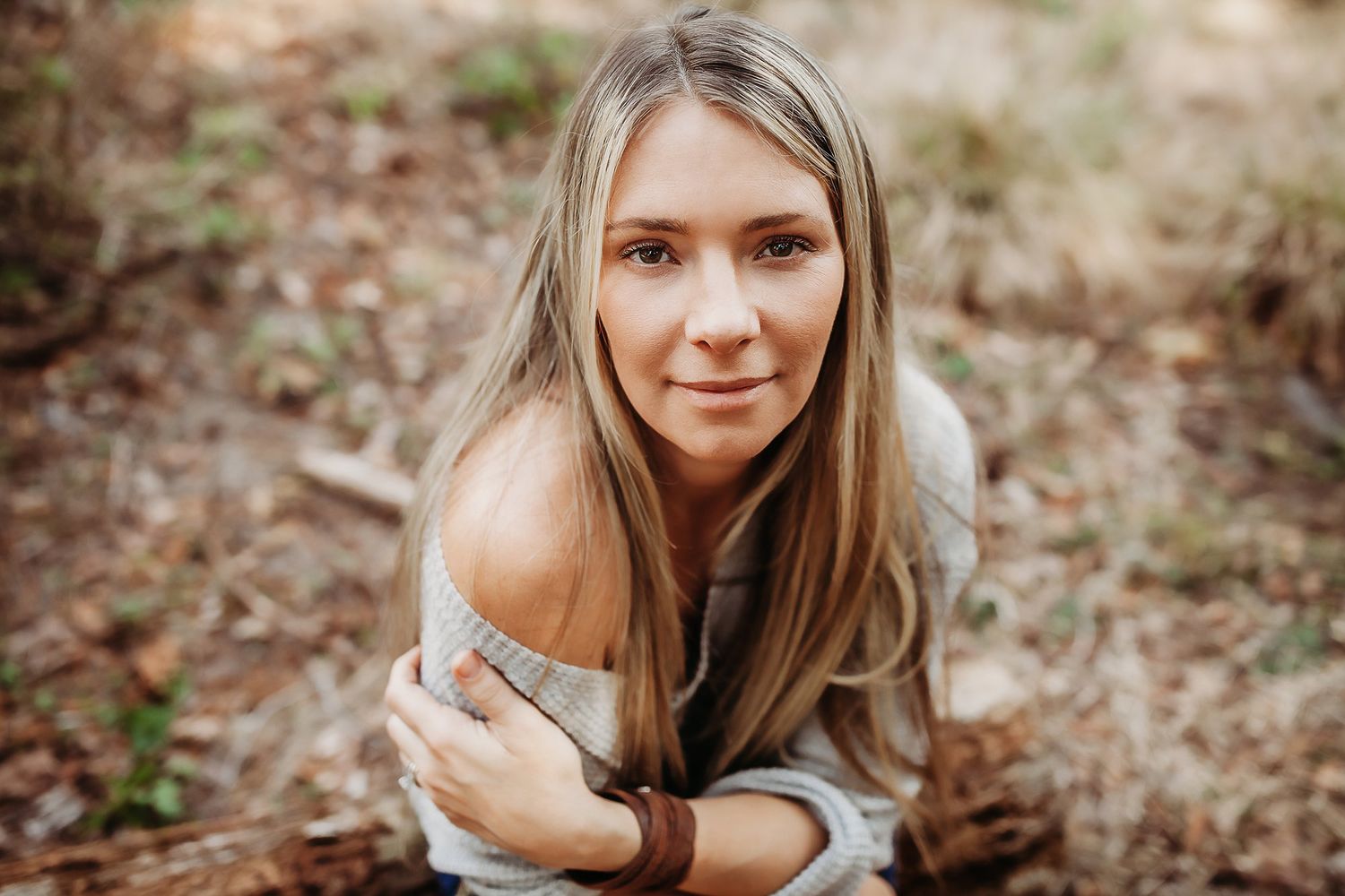 A series of outdoor portrait photographs showing someone with long hair lying on autumn leaves in a natural setting.