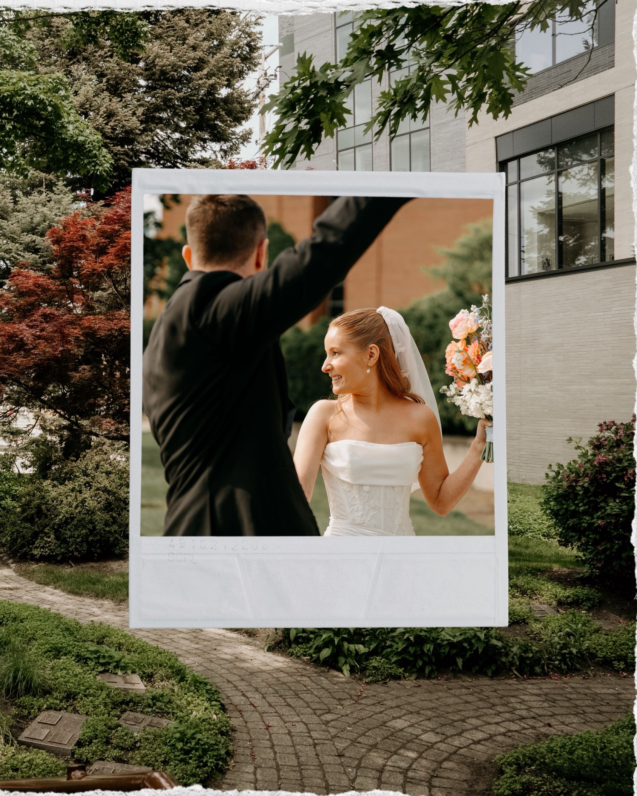 Elegant wedding couple shares a joyful moment together on a stone pathway surrounded by lush greenery and trees.