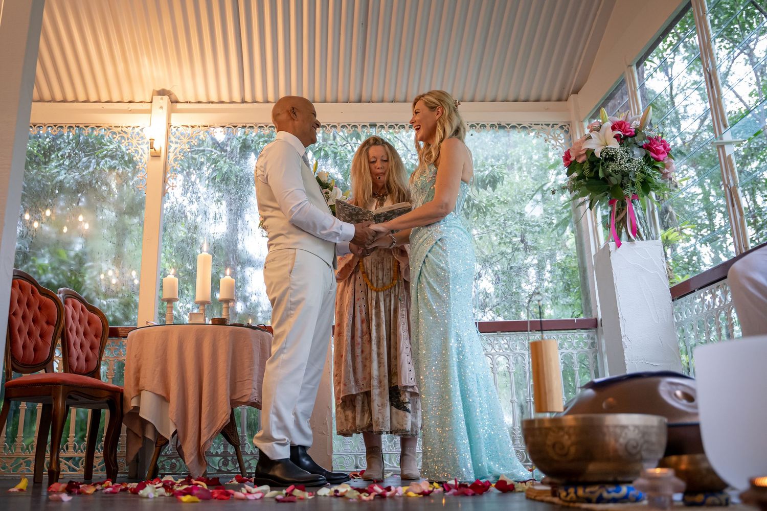 A series of connected images showing dancers in white dresses performing graceful movements on a covered porch.