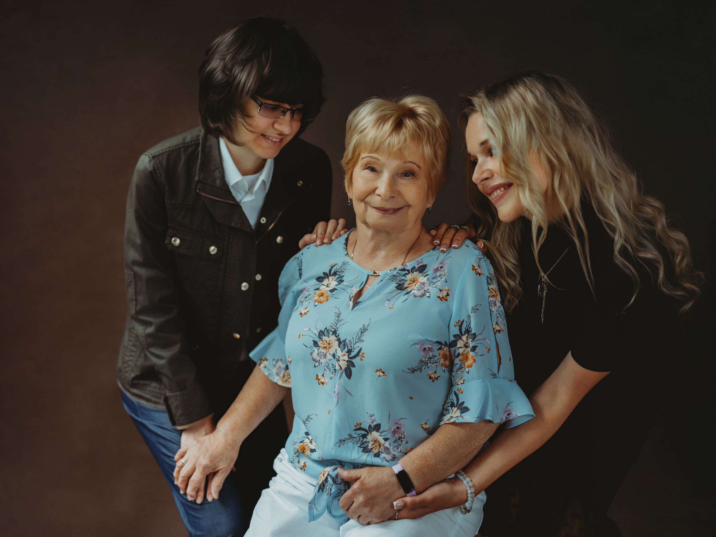 A series of candid family moments captured in a dark moody setting with people wearing blue and black clothing.