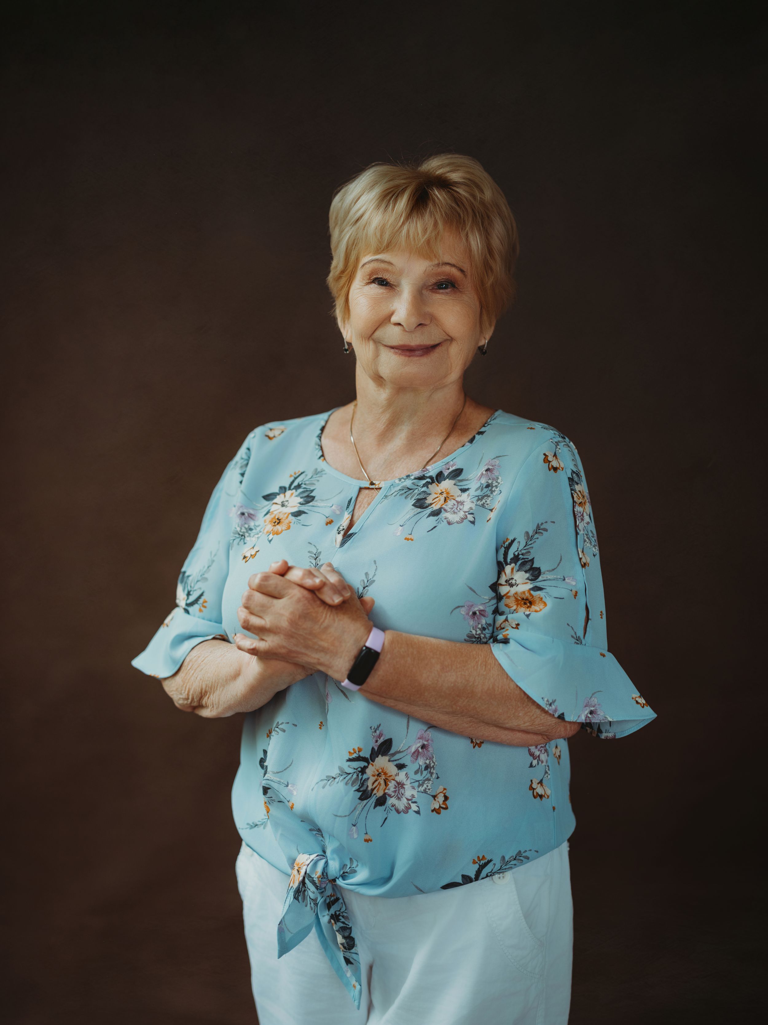 A series of photos shows someone in a light blue floral top demonstrating sign language gestures against a dark background.