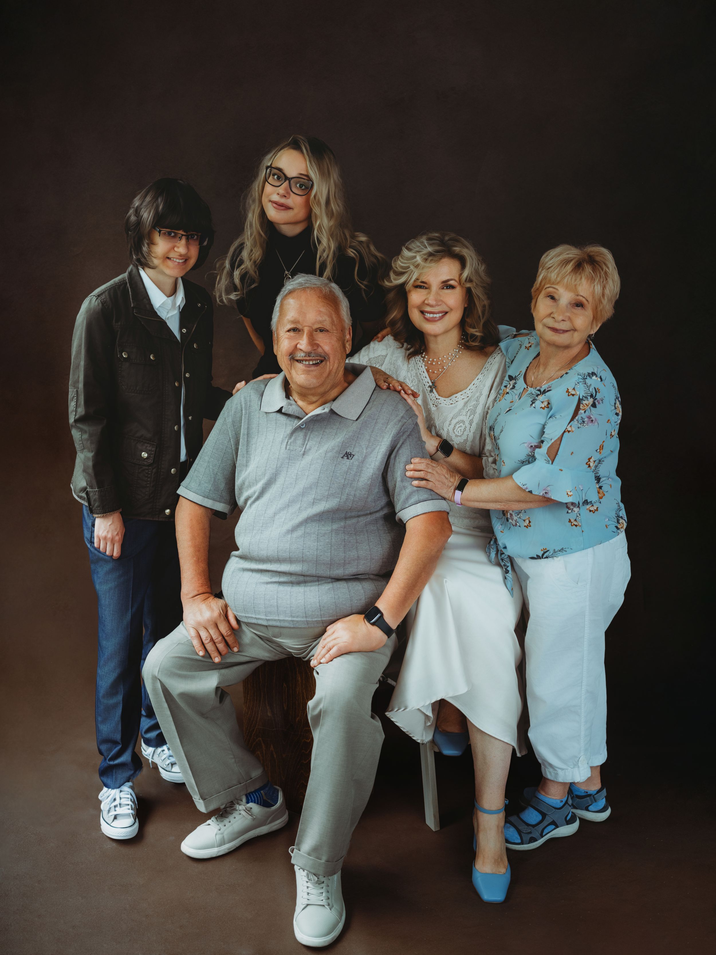 A series of candid family portraits showing tender moments between generations against a dark background.