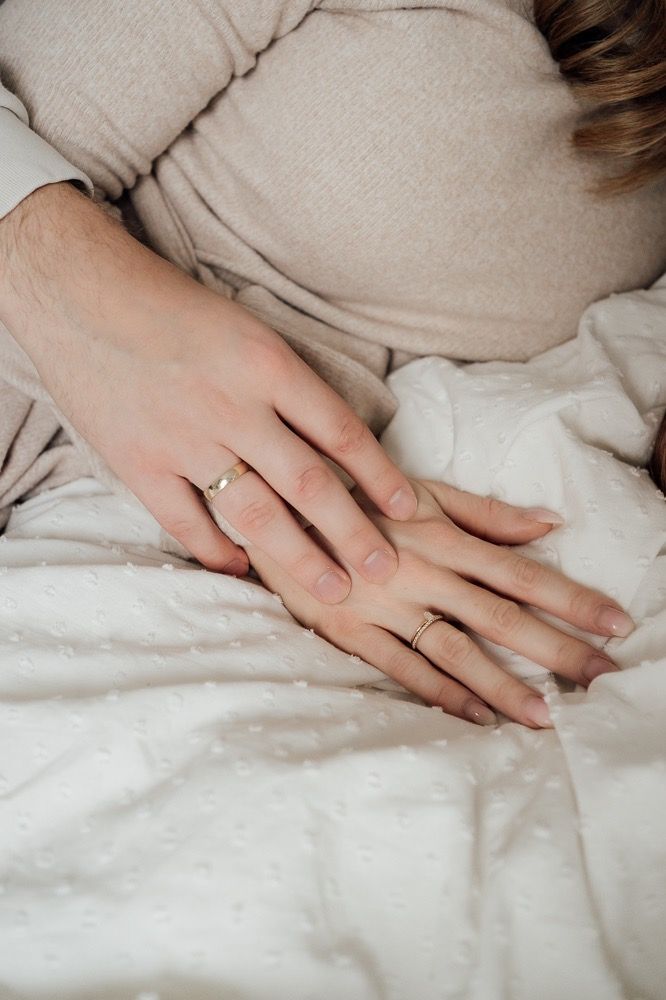 A sequence of hands on white bedding showing a gentle caressing motion from left to right.