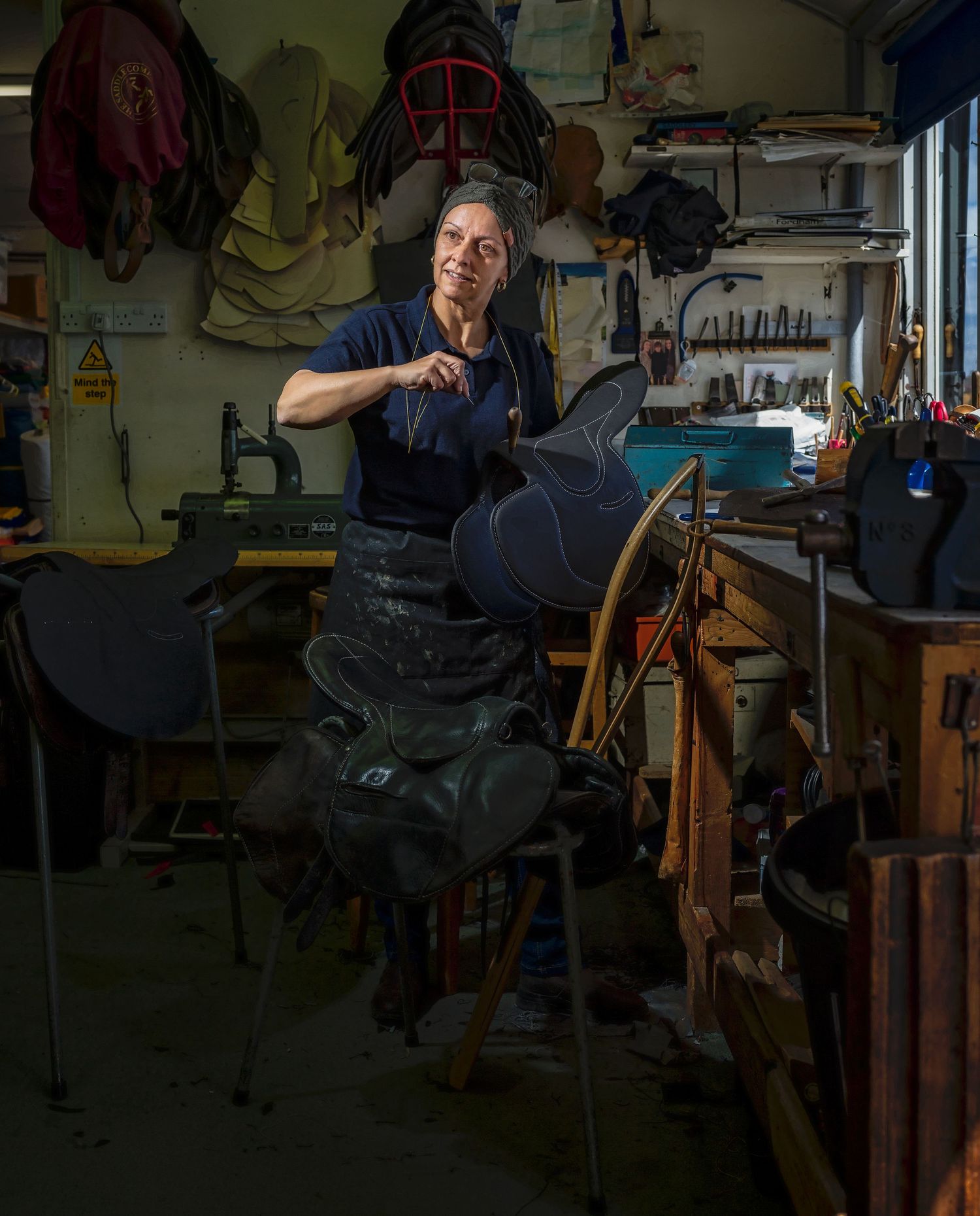 Editorial portrait of saddlemaker Samantha Pett working in her workshop, Newmarket, Suffolk.