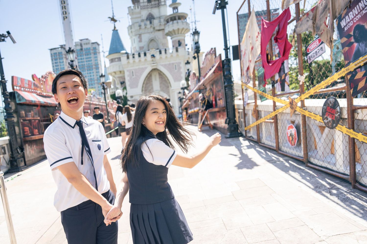 Visitors enjoy taking photos and exploring attractions at Tokyo Disneyland theme park on a sunny day.