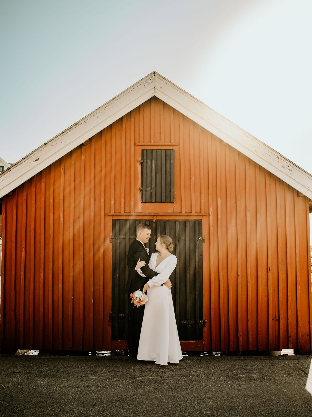 A series of five photos showing a person in white dress opening and closing a rustic orange barn door.
