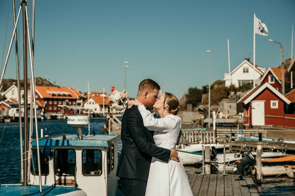 A series of connected images showing a coastal marina with boats, docks, and traditional red buildings along the waterfront.