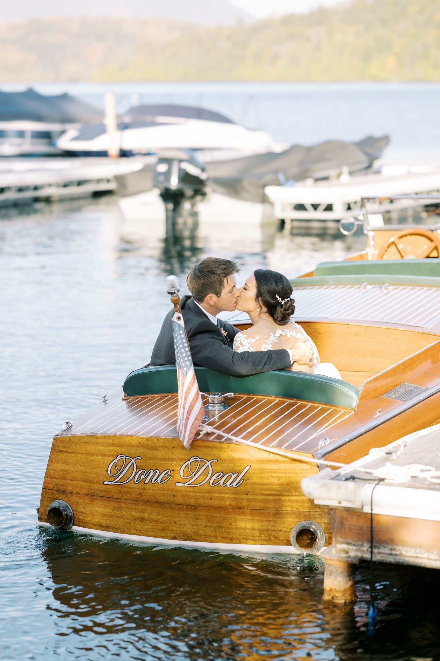 A Chris-Craft boat glides through Lake Placid on a sunny day, showcasing its classic vintage design.