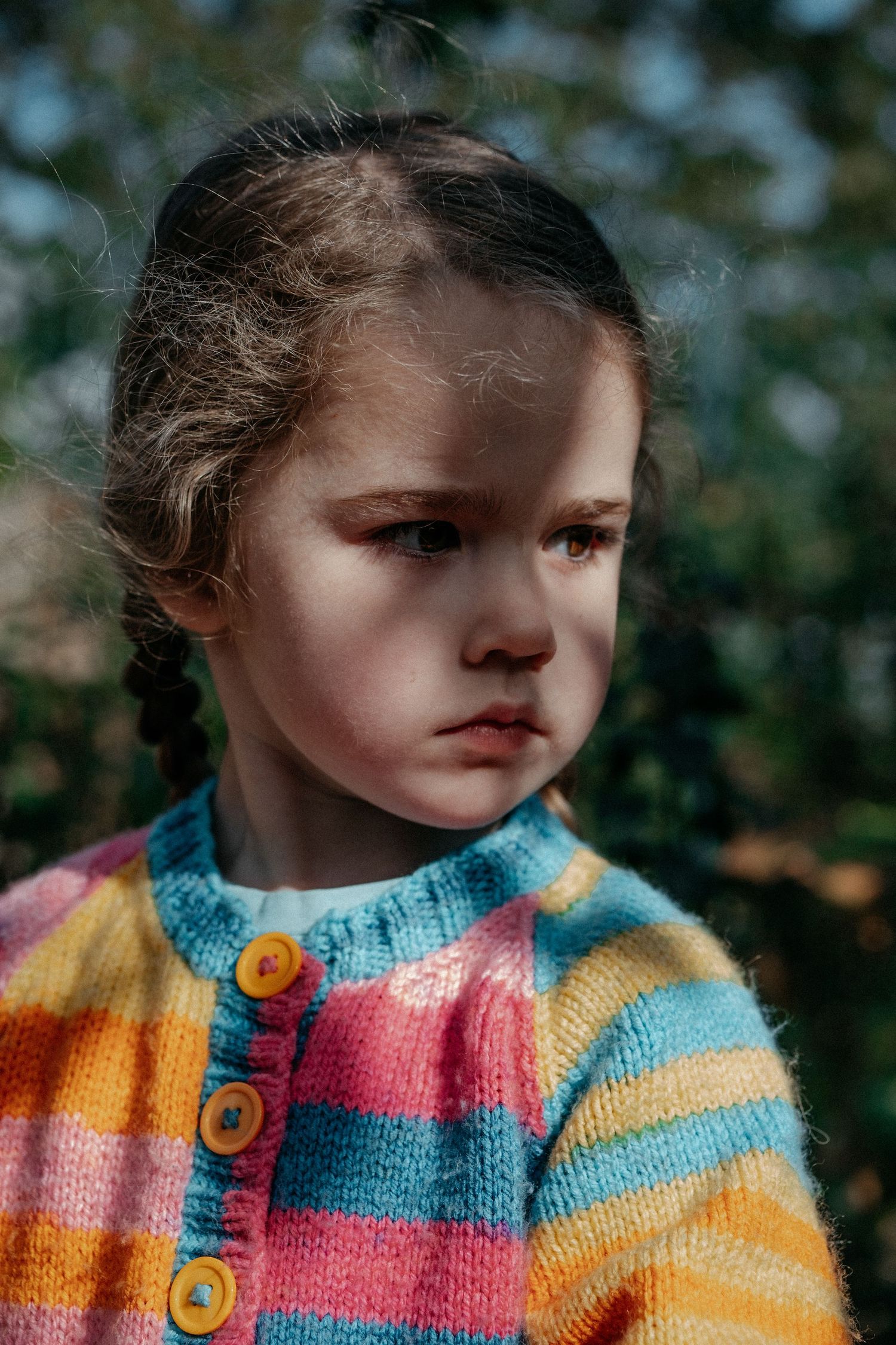 Outdoor portrait of a young child looking thoughtfully to the side during a natural lifestyle family photography session in Tynemouth