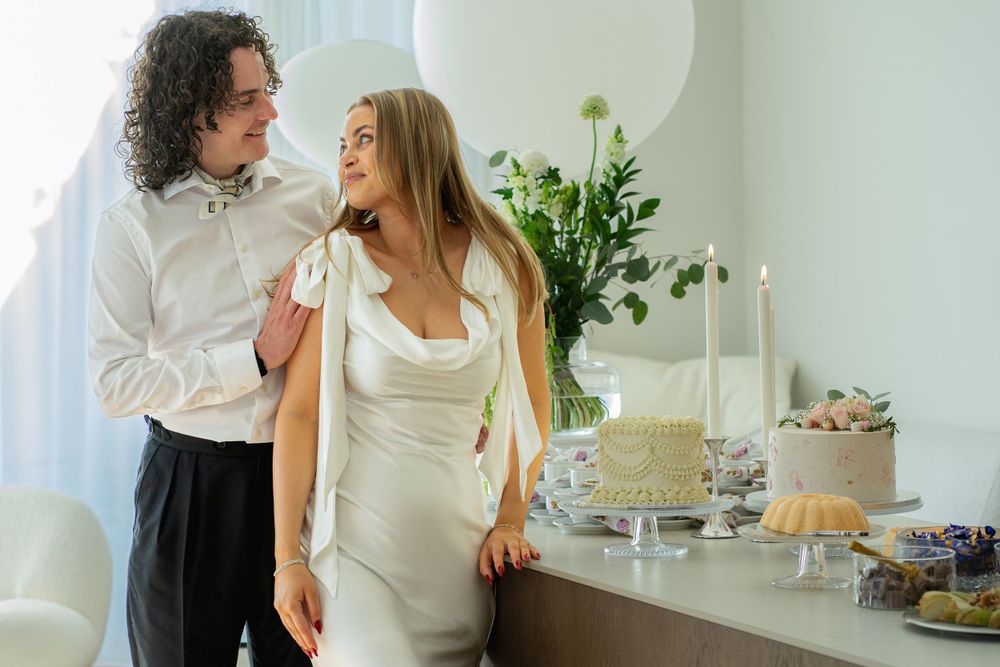 A celebratory moment captured near an elegant dessert table with white decor.