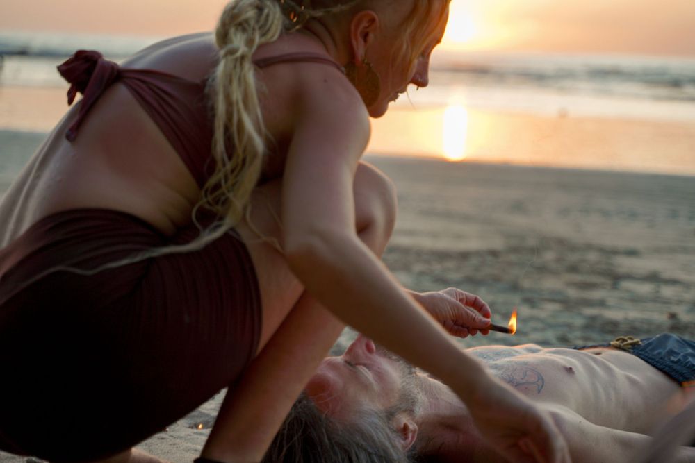 A healing session taking place on a beach at sunset.