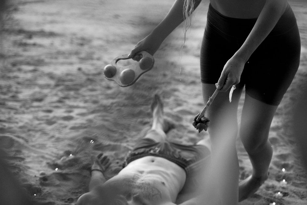 Alternative therapy session shown in black and white on a beach.