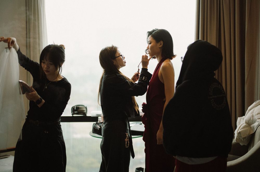 A series of people having intimate conversations in pairs while standing together in a room.