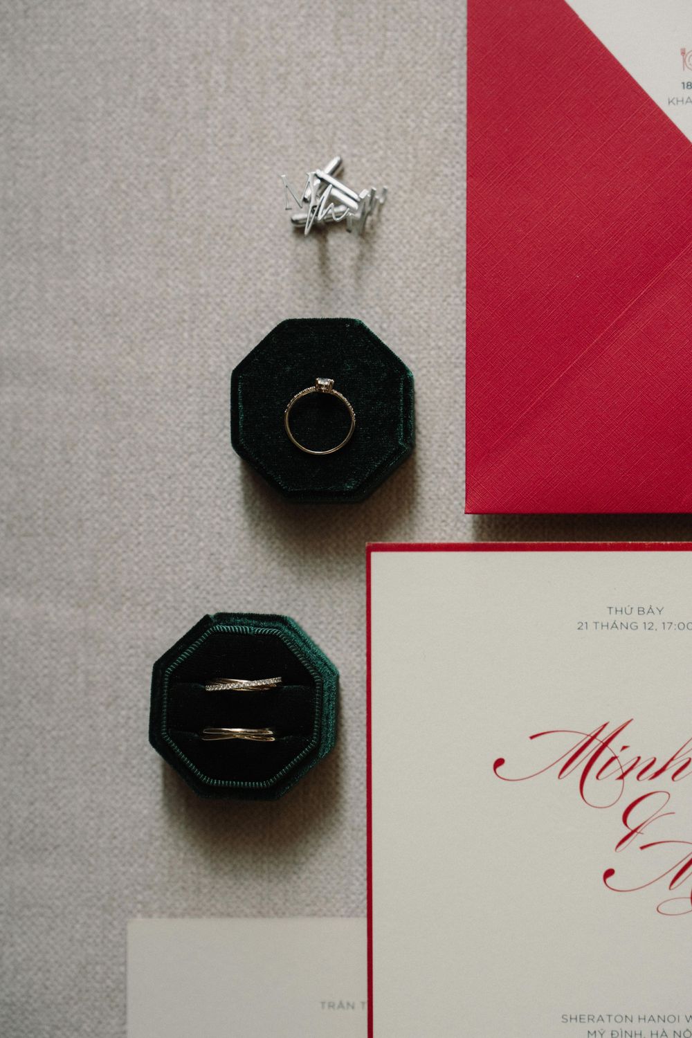 A wedding invitation suite featuring elegant red envelopes and black ring boxes with metallic calligraphy details.