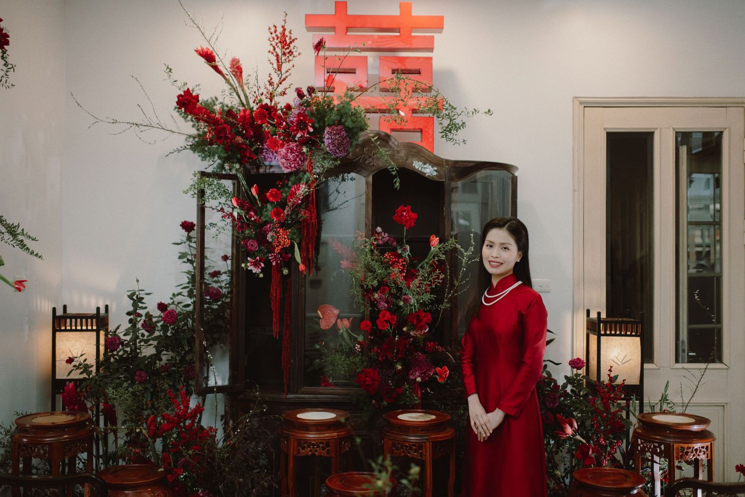 A wedding venue decorated with red plum blossoms and traditional Chinese decor creates a festive Lunar New Year atmosphere.