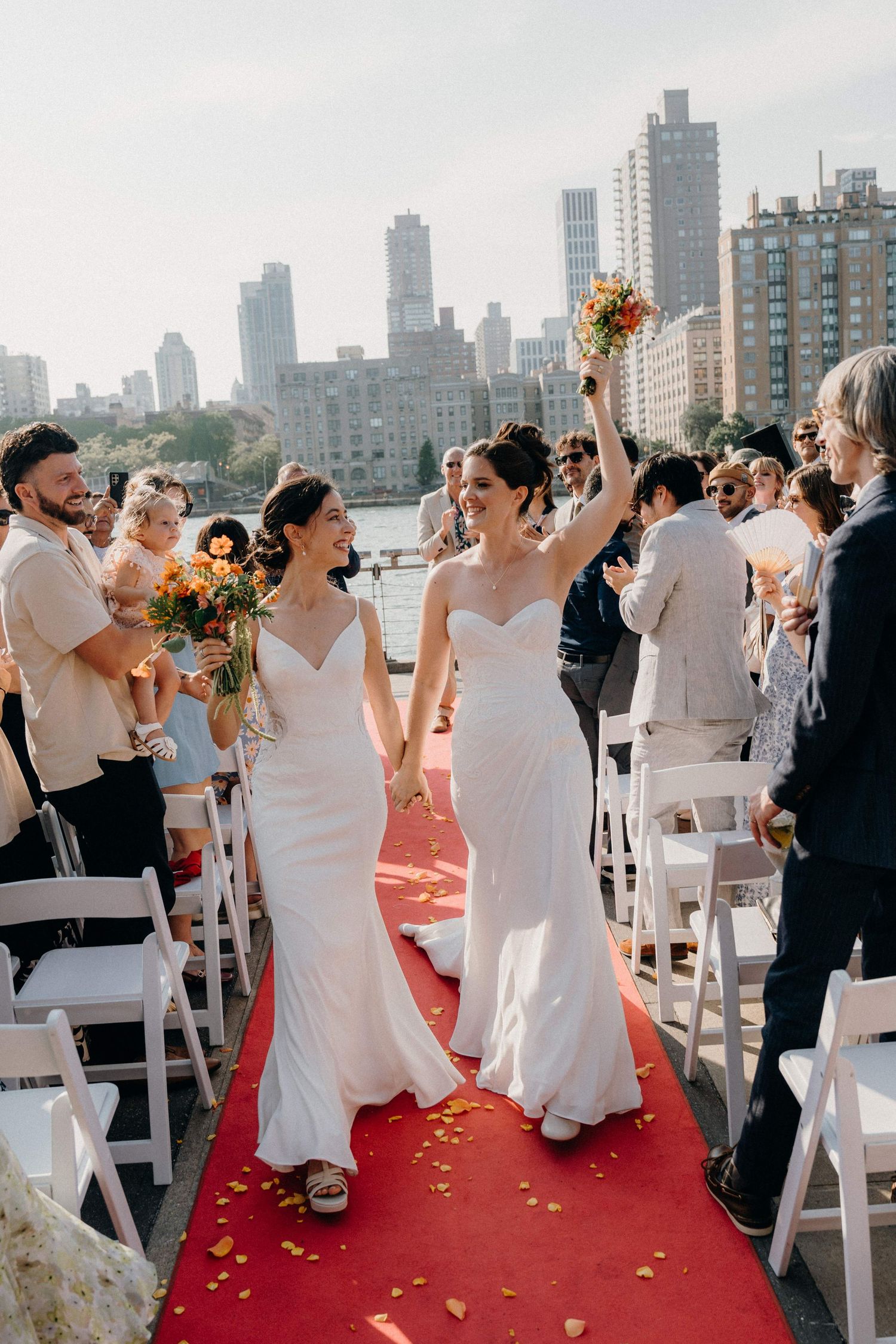 Wedding celebration at The Sanctuary Roosevelt Island NYC skyline backdrop during sunset.