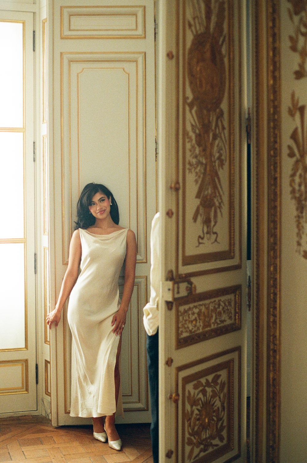 A progressive sequence of a woman in a cream dress emerging from behind ornate gold-trimmed palace doors.