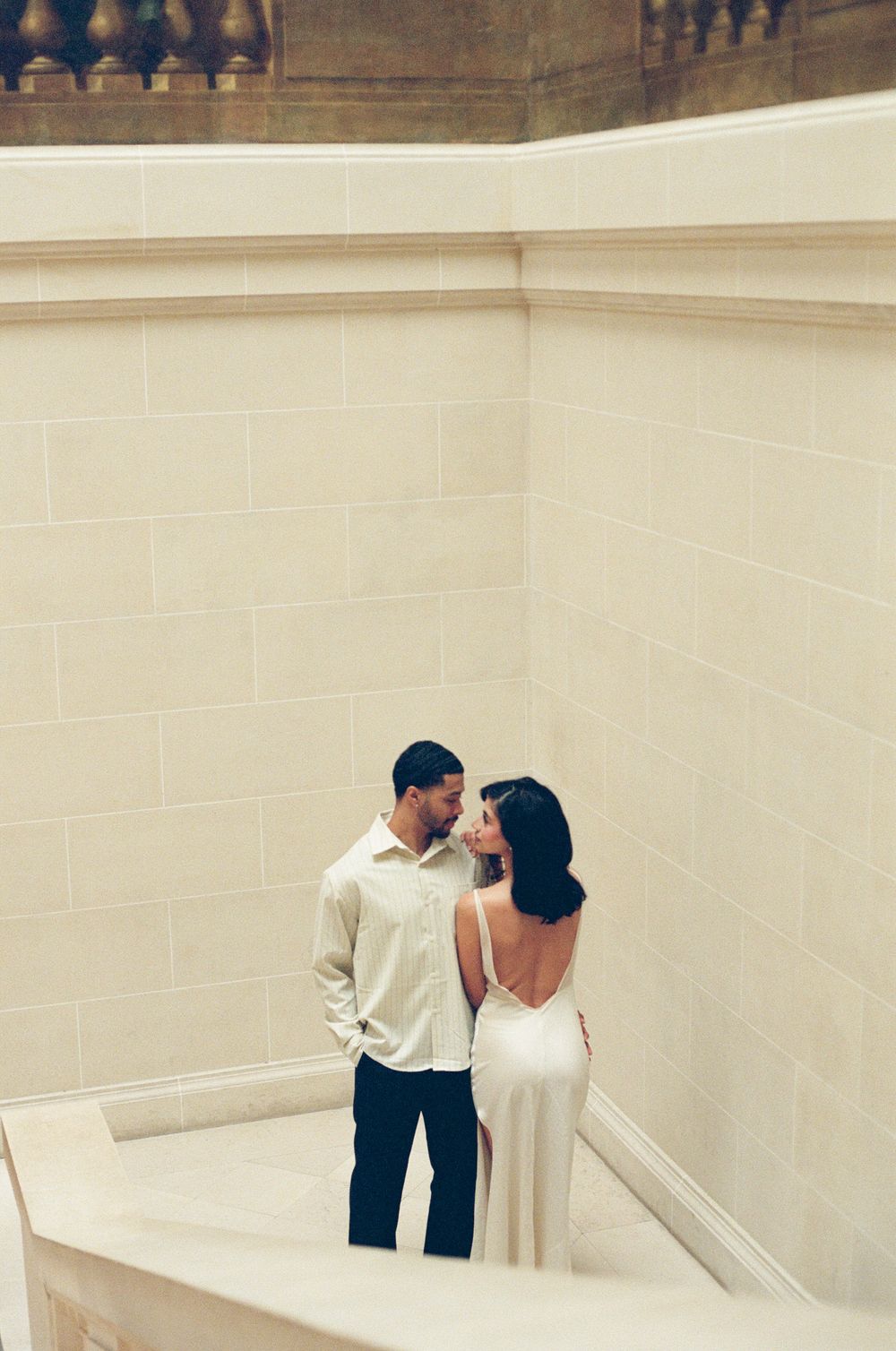 A minimalist photo series showing two figures interacting in white architectural corners and spaces.