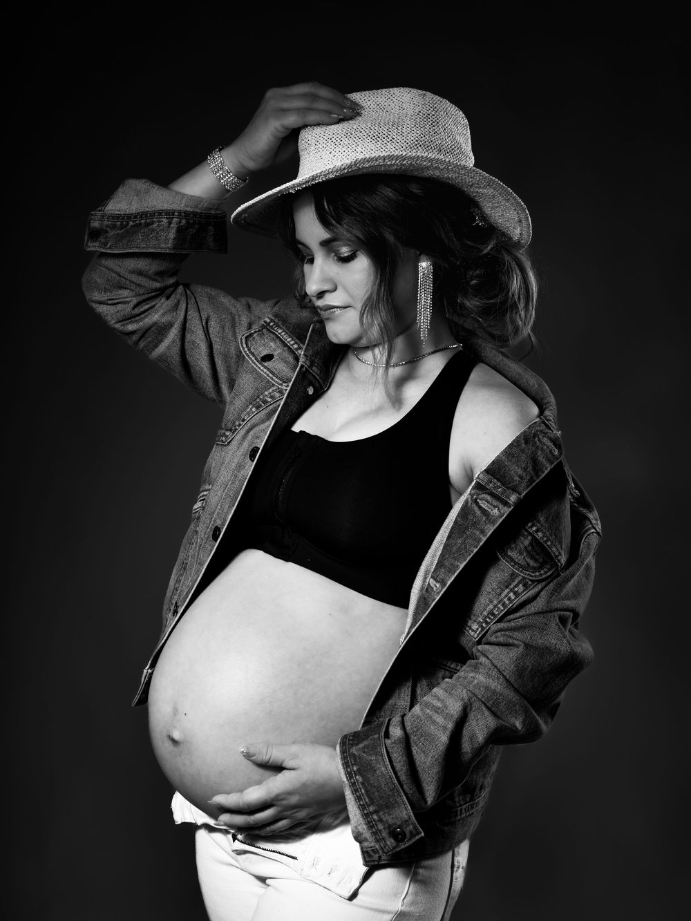 Artistic black and white maternity photos with denim jacket poses.