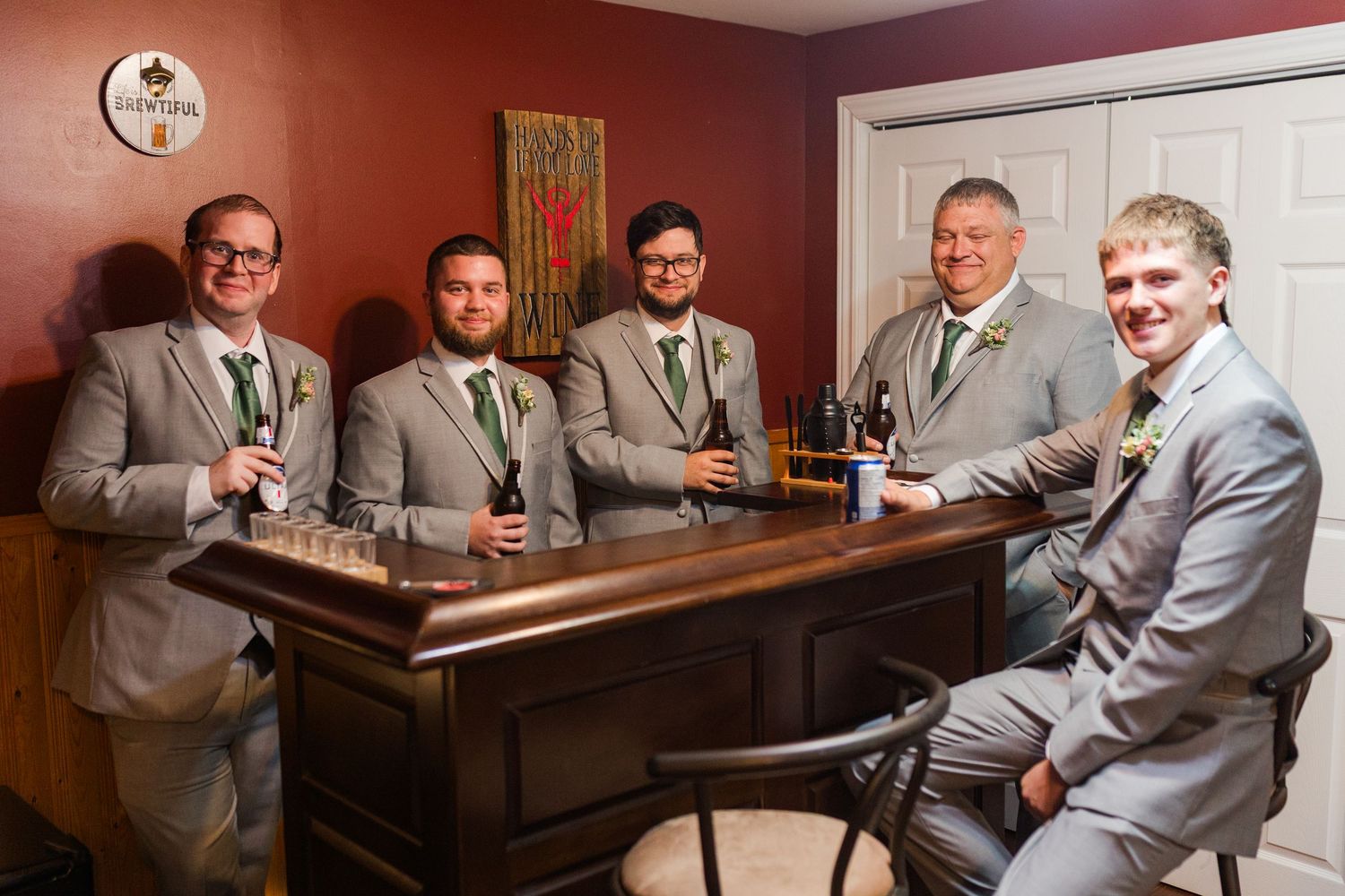 A group of people in formal gray suits gather around a table at what appears to be a restaurant booth.