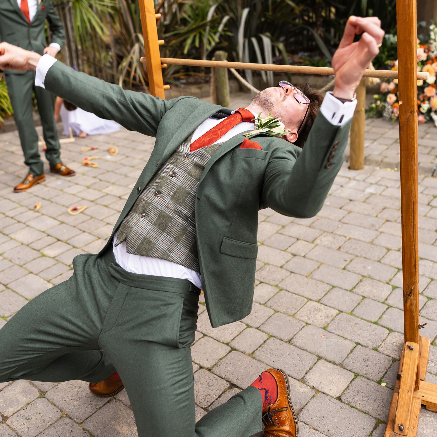 Outdoor wooden swing adorned with white fabric and greenery for rustic garden wedding ceremony setting.