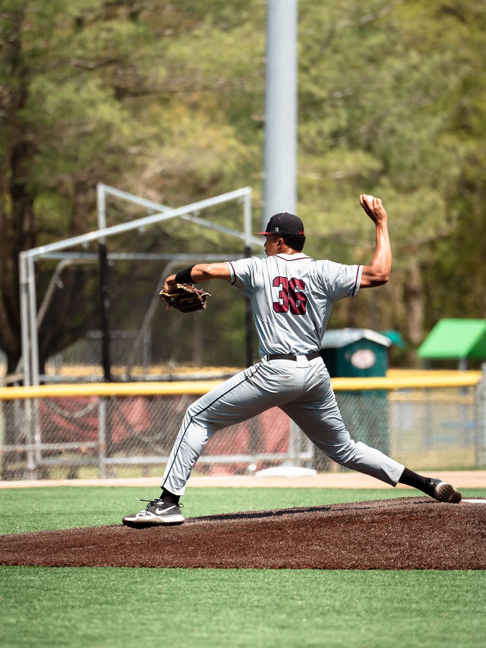 Baseball pitcher captured in five sequential motion frames showing complete throwing delivery from wind-up to follow through.