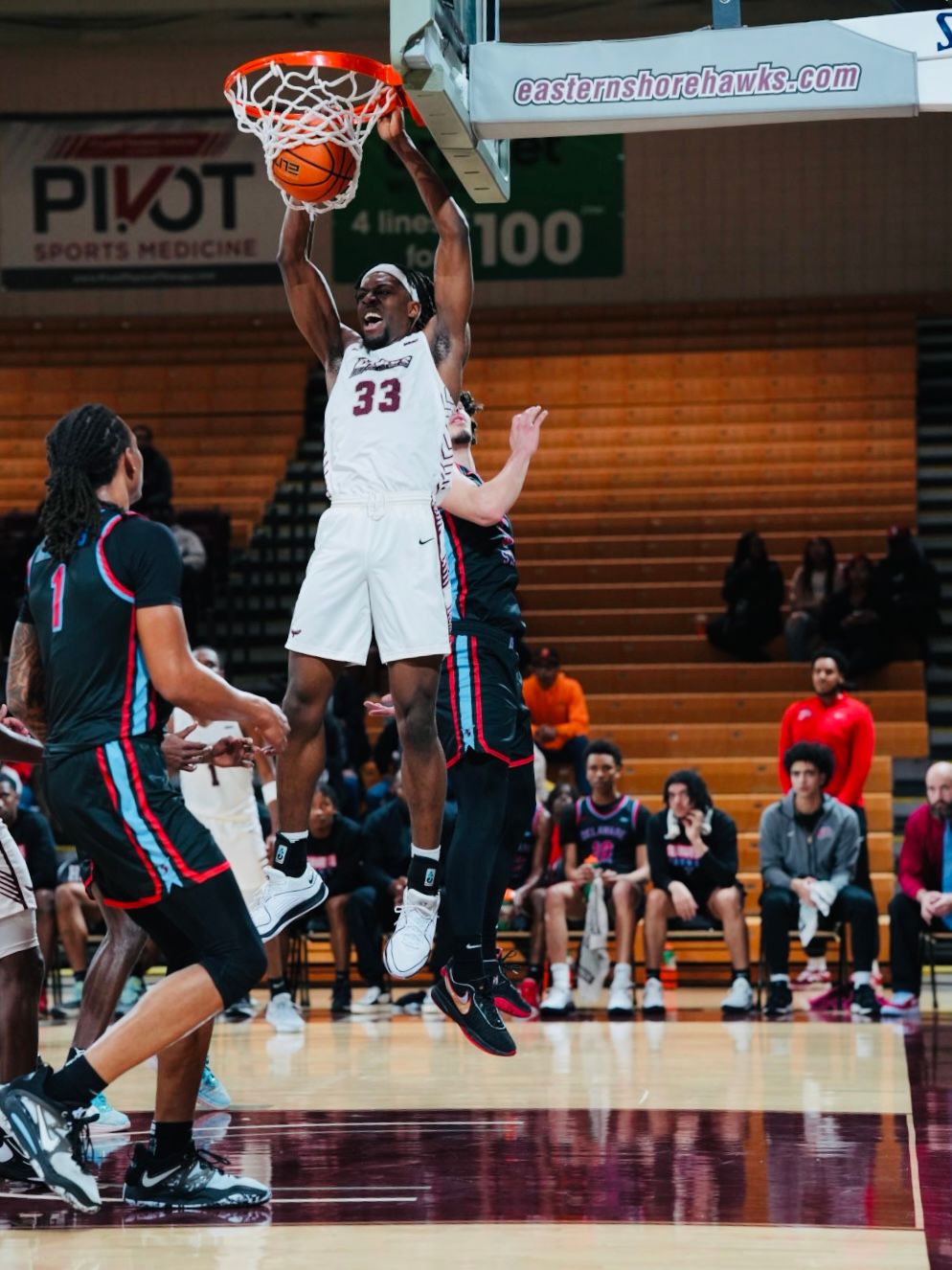 Basketball players compete for possession during an intense game on the hardwood court.