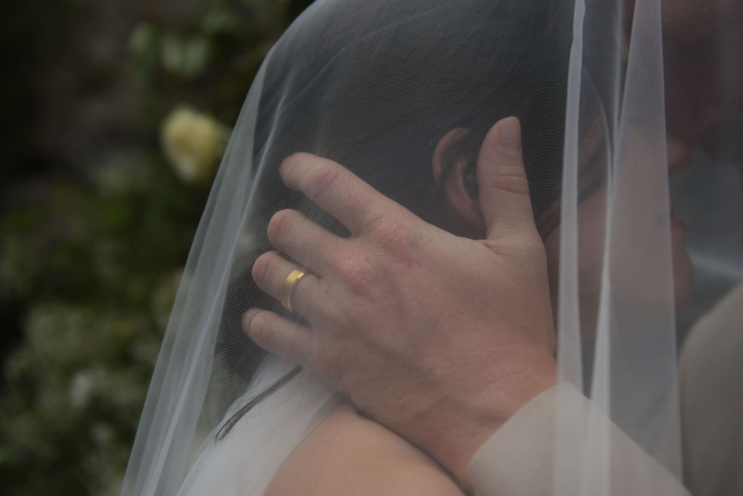Close-up wedding portrait detail with delicate veil and soft lighting.