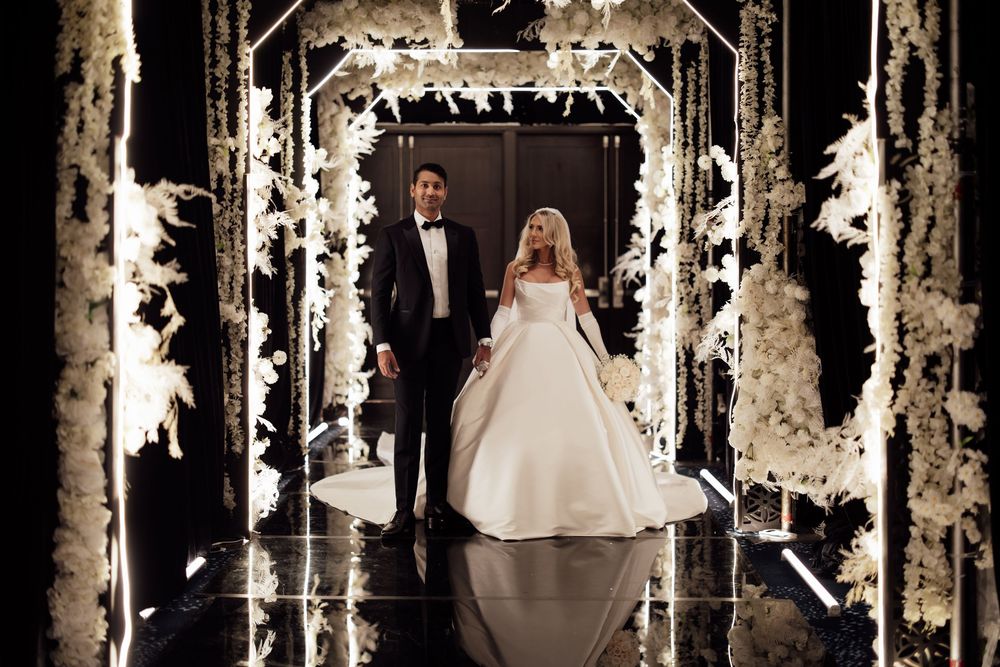 A stunning winter-themed wedding ceremony setup with birch trees, white lights and decorative snowy details.