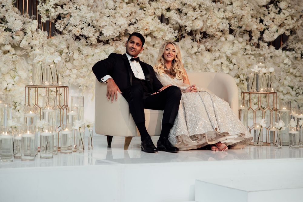 Elegant wedding scene with floral archway and white decor capturing romantic moments on the dance floor.