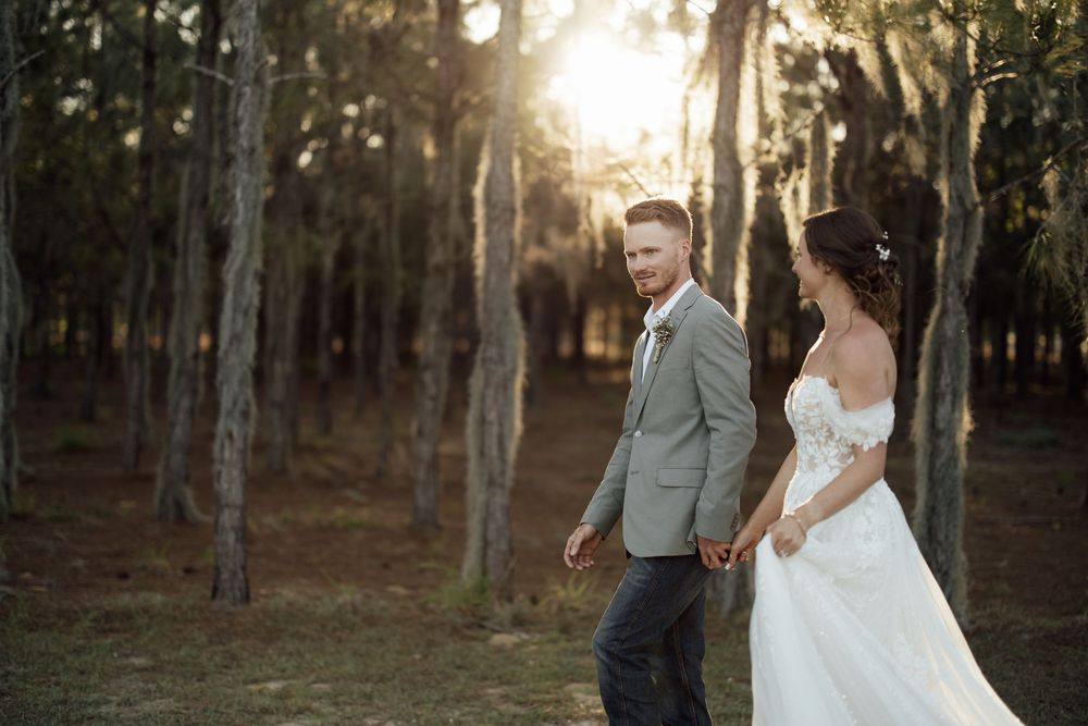 Newlywed couple shares romantic sunset moment in forest during golden hour photo session.